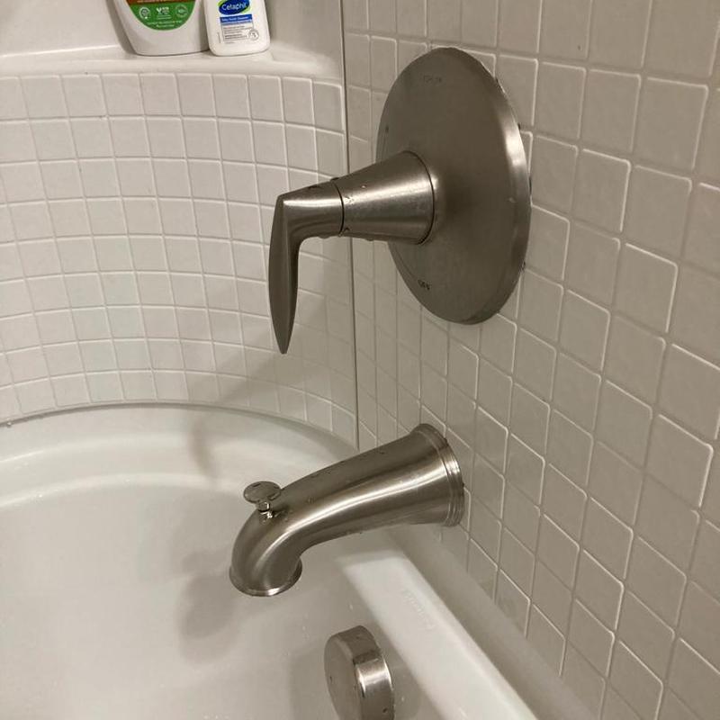 Bathroom tub spout and faucet with white tile wall Bathroom tub spout and faucet with white tile wall