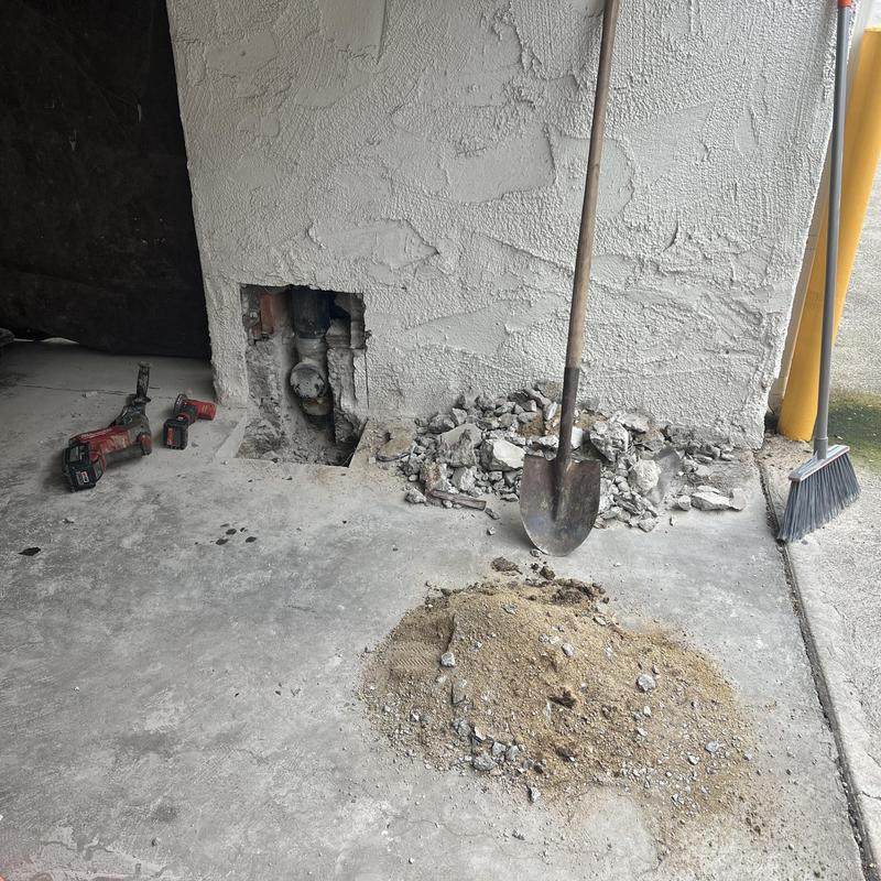 Cast iron sewer clean out tee in wall with tools