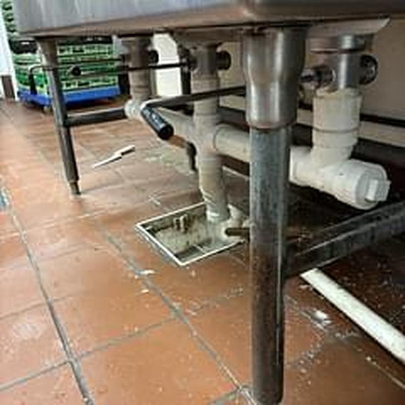 Drain pipes under three compartment sink with lever stoppers