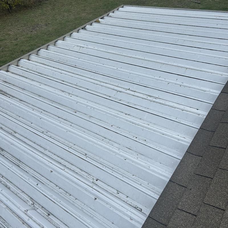 Metal roof panel close-up with shingle edge