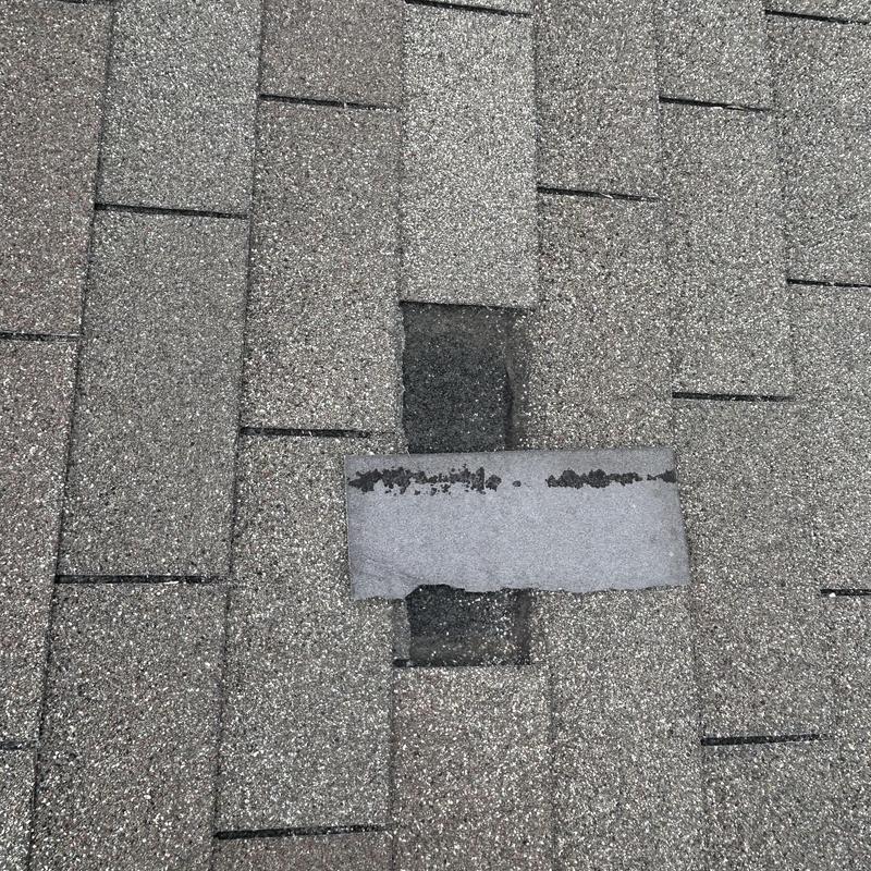 Asphalt roof shingle with visible damage and wear