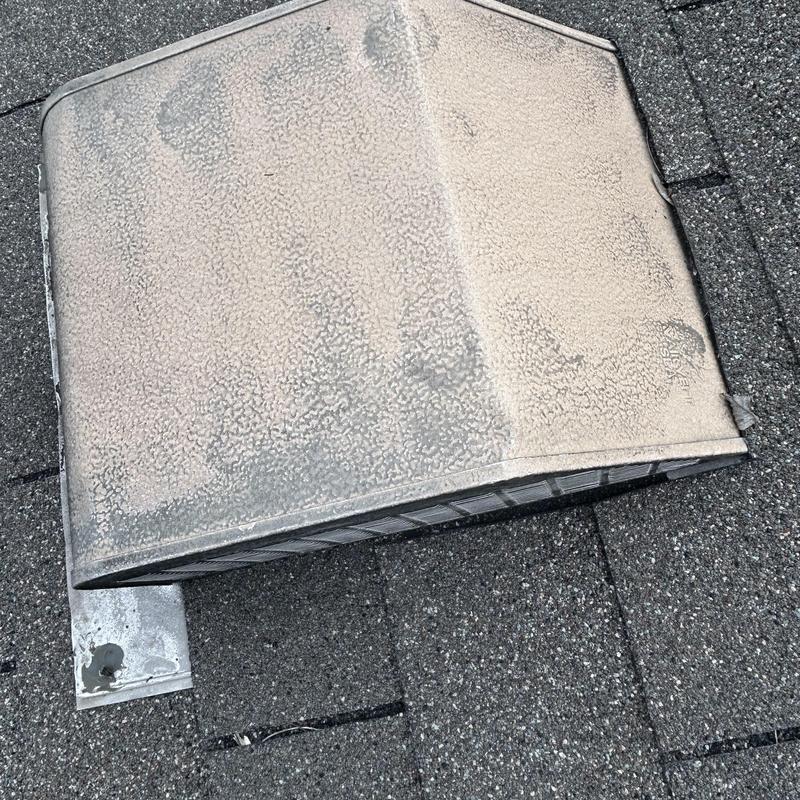 Roof vent cap with weathered and damaged shingles