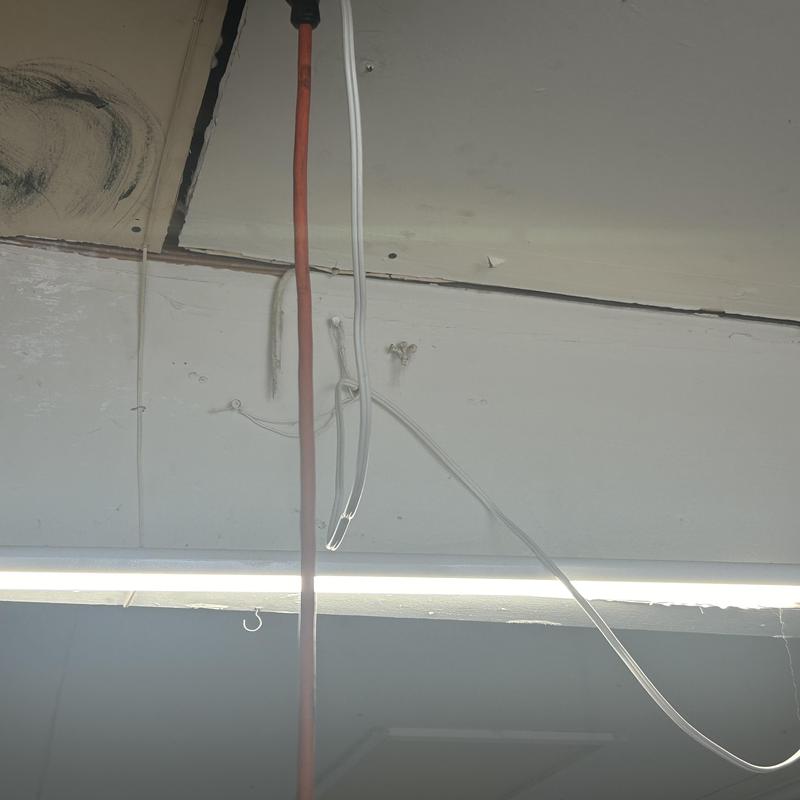Garage ceiling drywall with exposed wiring and stains