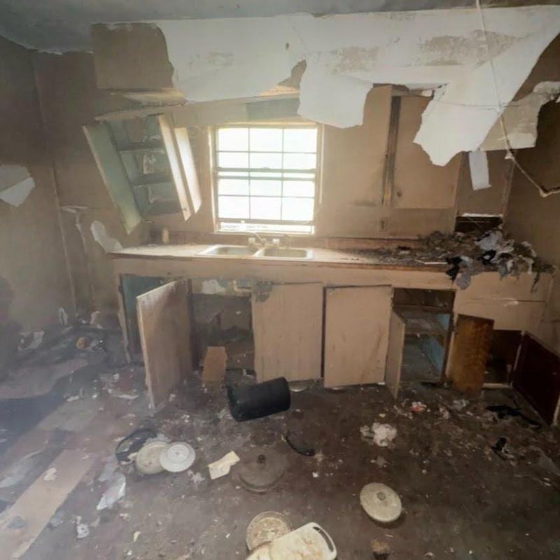 Kitchen cabinets and sink in gutted home renovation site