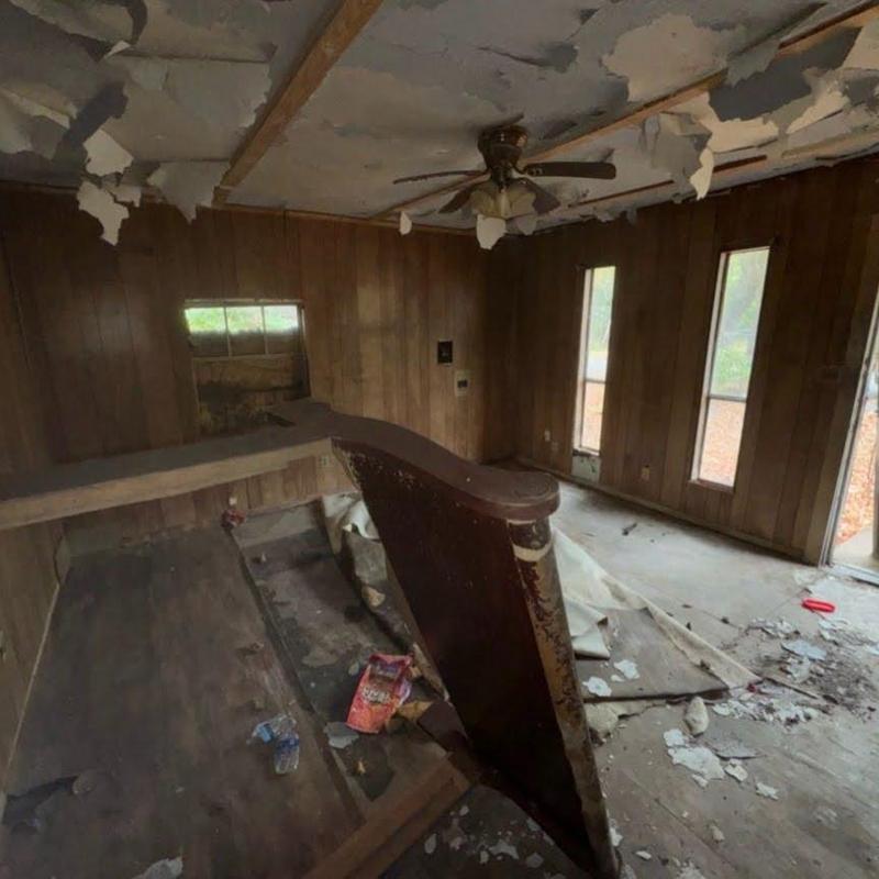 Ceiling fan and wood paneling in damaged room