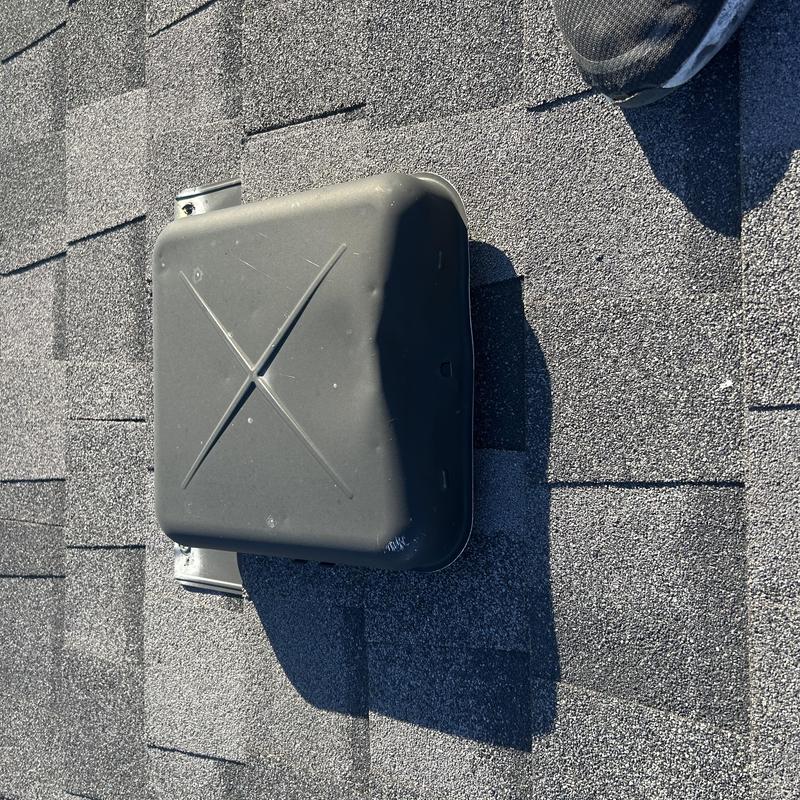 Roof vent cover on asphalt shingle roof surface