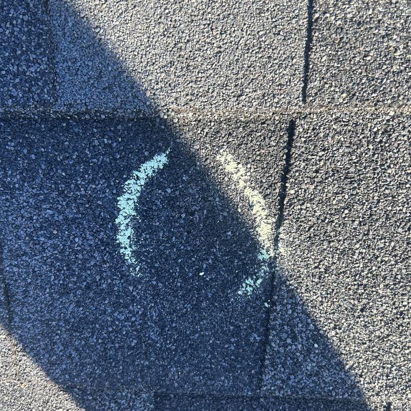 Asphalt shingle roof with hail damage marked in chalk