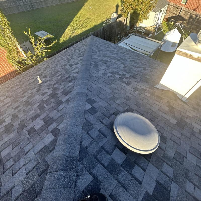 Asphalt shingle roof with vent and chimney in sunlight