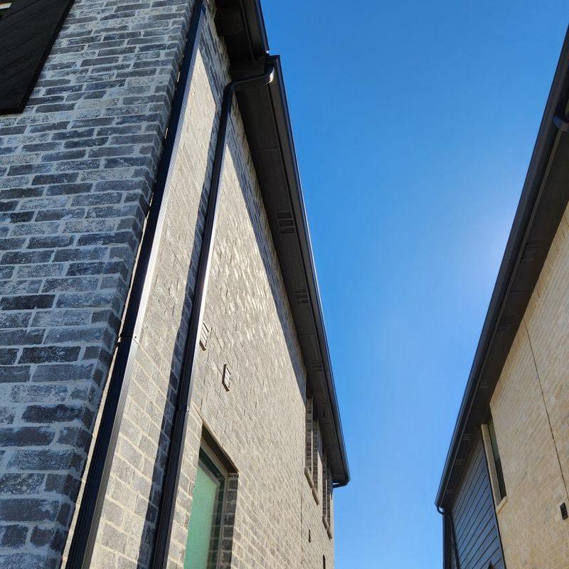 Gutter and downspout installation on brick house