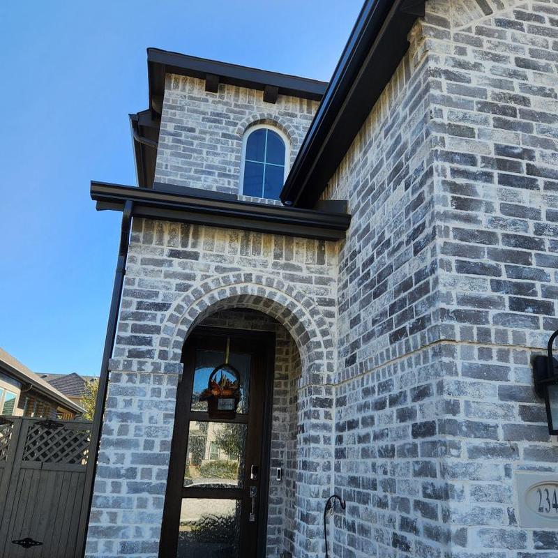 Gutter and downspout on brick house exterior
