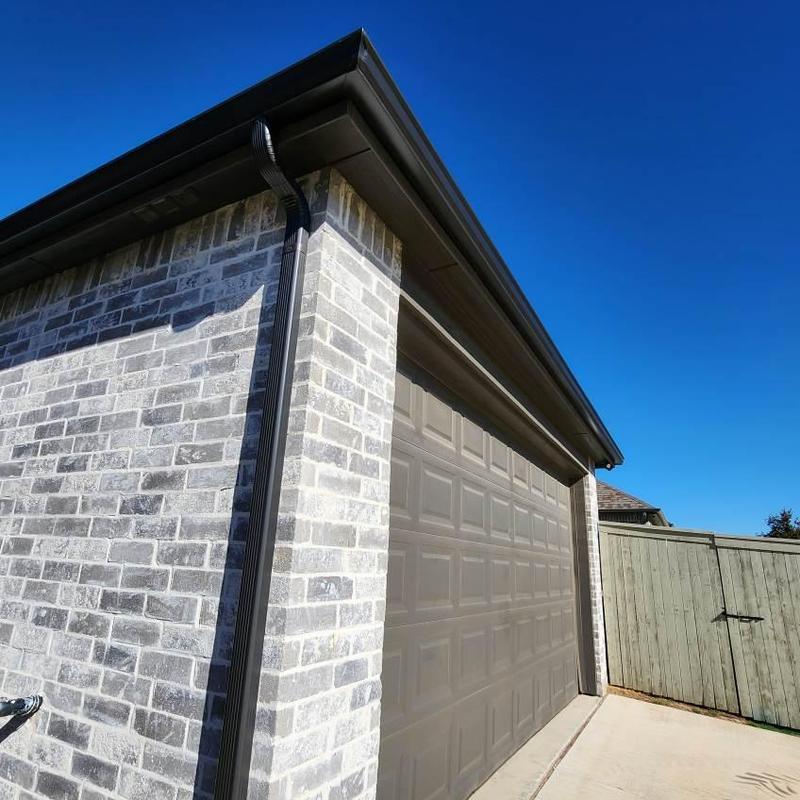 Gutter and downspout system on brick garage exterior