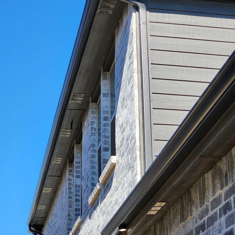Gutter and downspout system on gray brick house