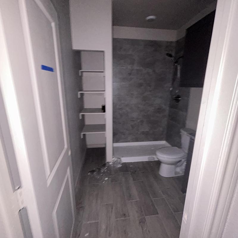 Bathroom shower and toilet with tile flooring