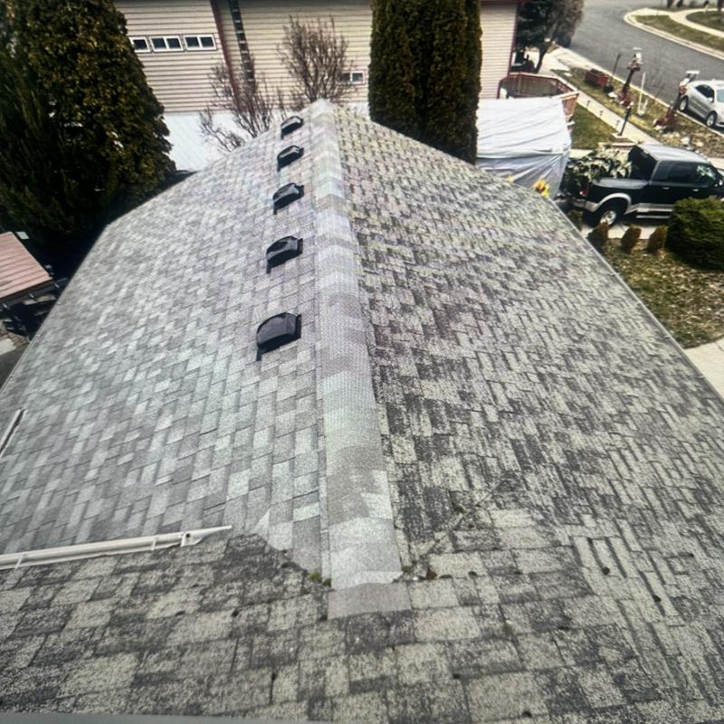 Asphalt shingle roof with new matching ridge cap installation