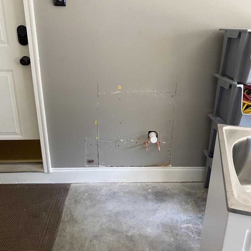 Mop sink plumbing installation in garage wall