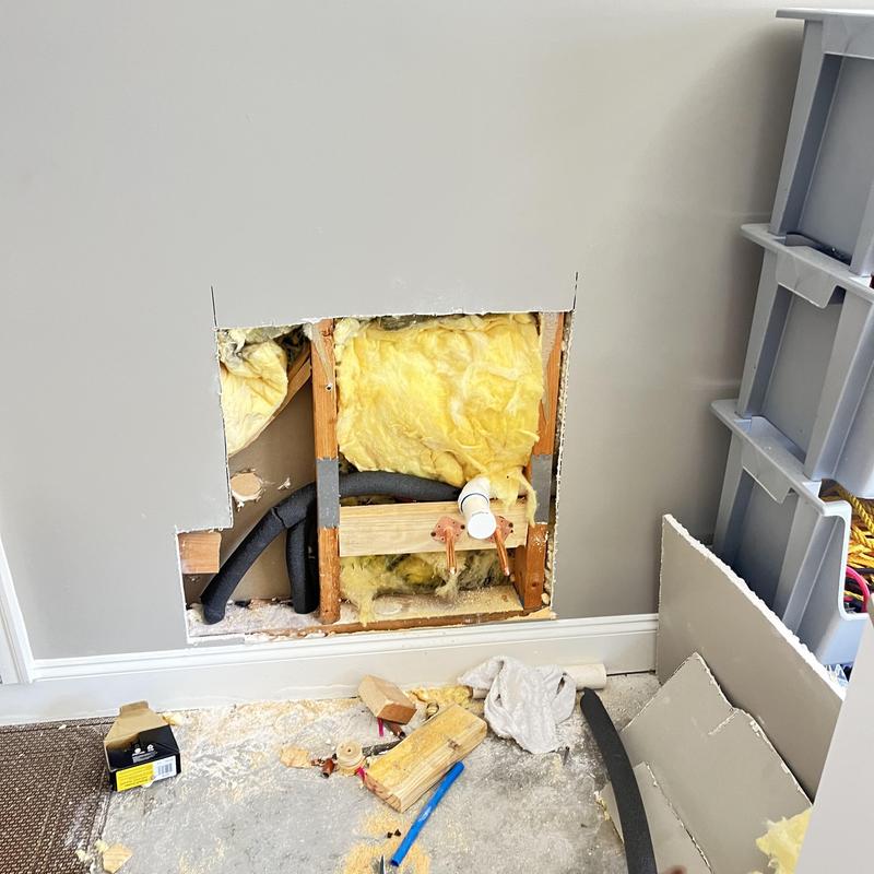 Mop sink plumbing rough-in behind drywall in garage