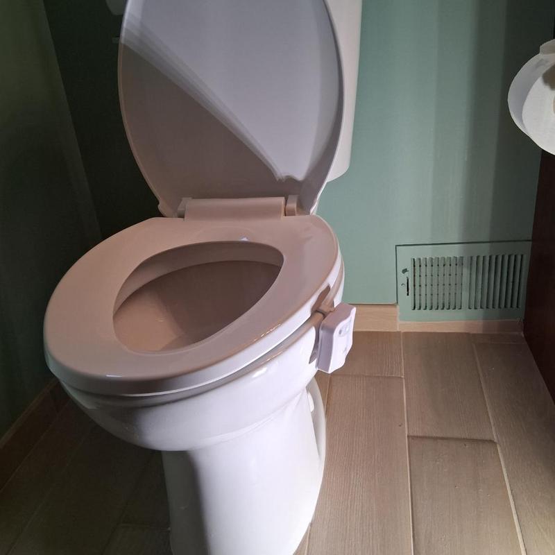 Toilet installation with open lid and new seat in bathroom