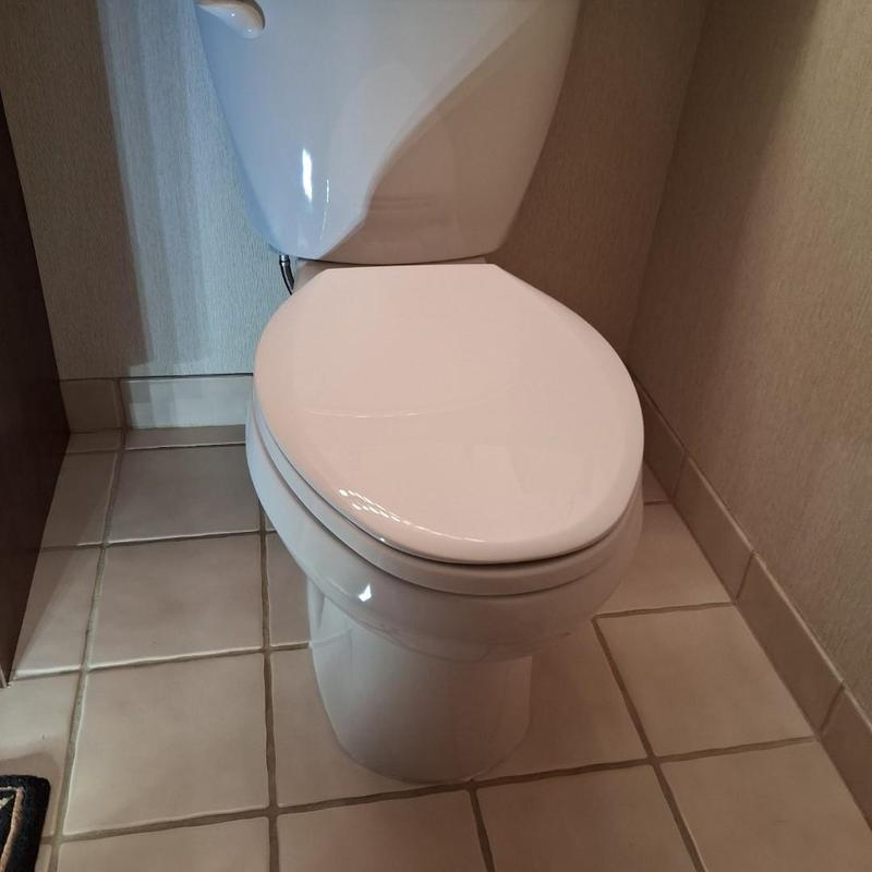Toilet replacement in bathroom corner on tiled floor