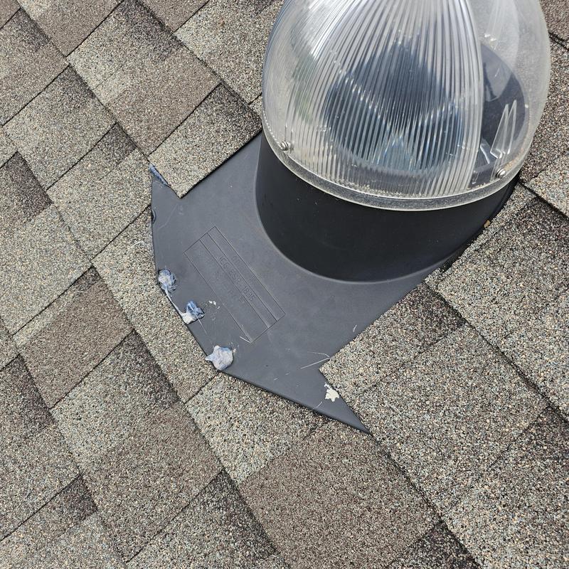 Skylight flashing and roof shingles with hail damage