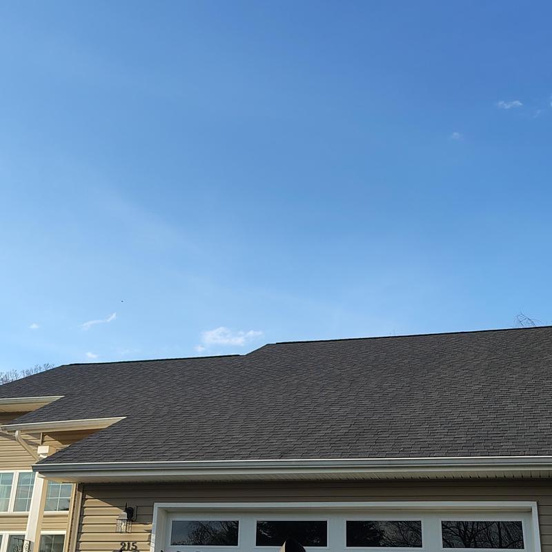 Atlas shingle roof installation under clear blue sky