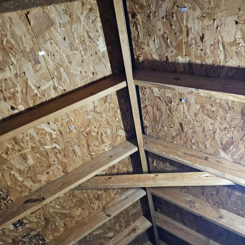 Roof sheathing with hail damage and wooden framing