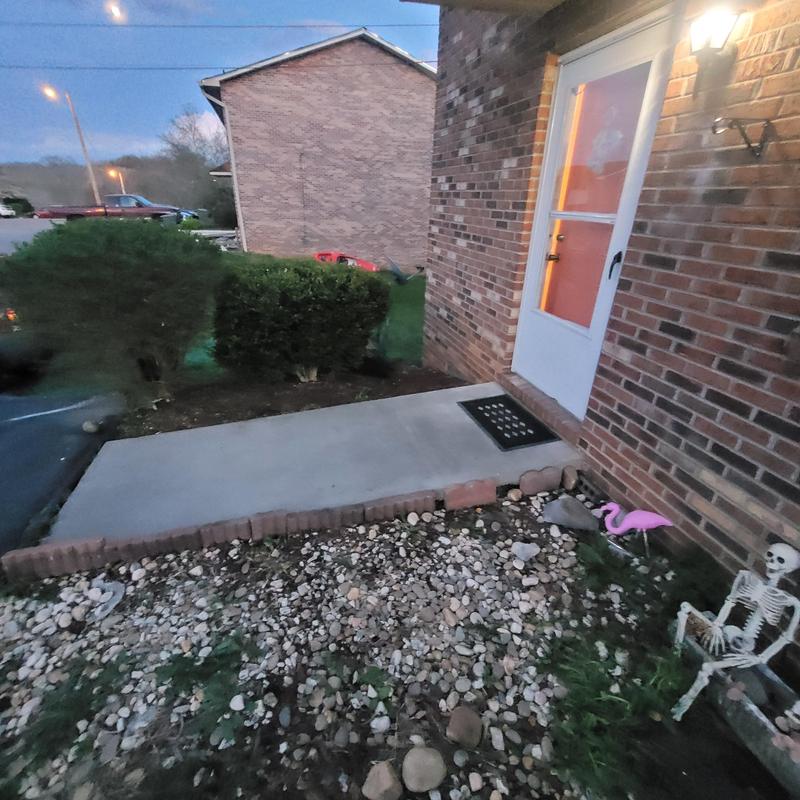Concrete patio slab with brick edging by home door