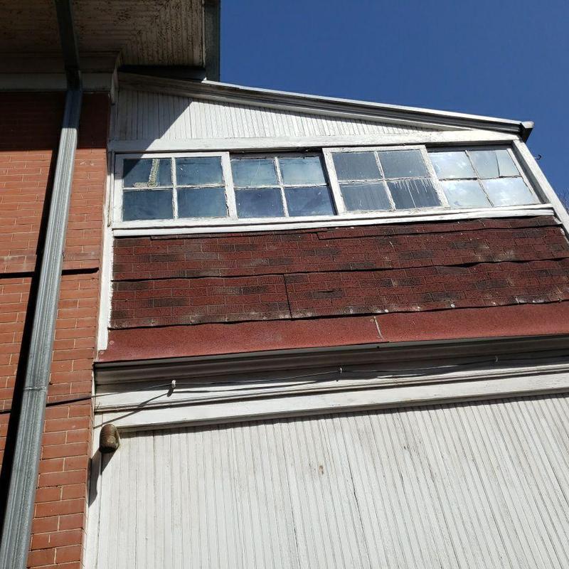 Shingle roof with damaged ridge cap and flashing