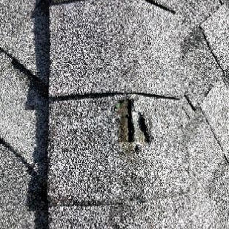 Roof shingle with damaged granule surface and hole
