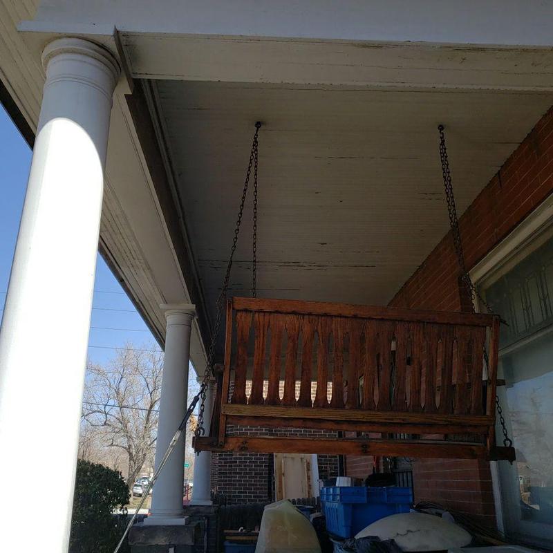 Porch swing mounted with hanging chains on covered porch