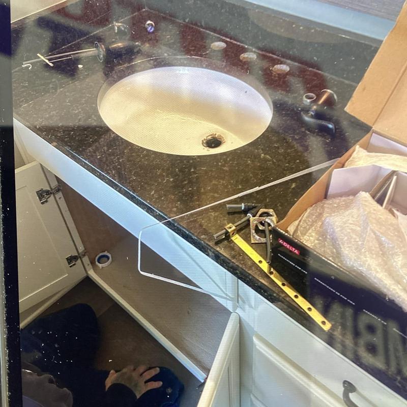 Bathroom sink faucet parts laid out for replacement