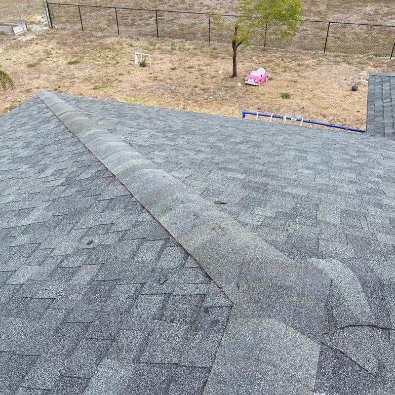 Shingle roof ridge with repaired hip and eave damage