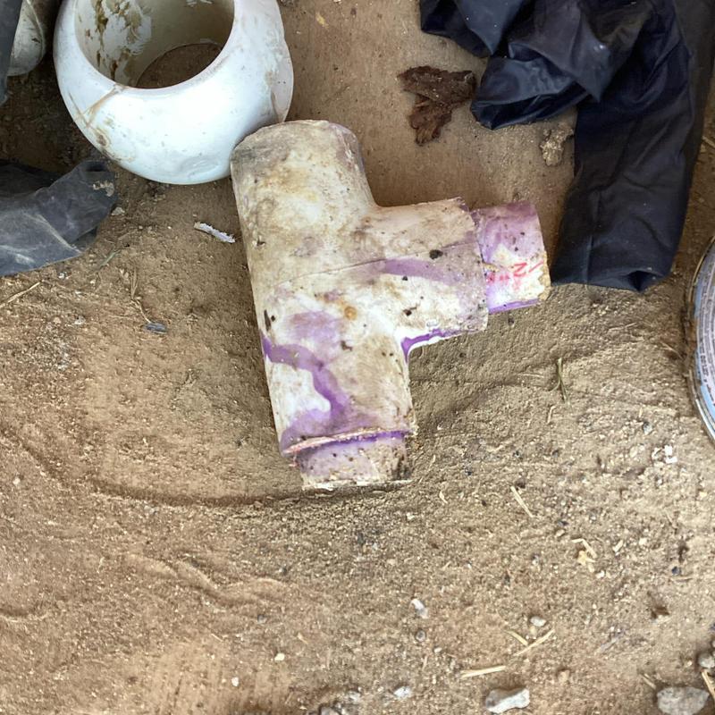 PVC pipe fitting with primer under house leak repair