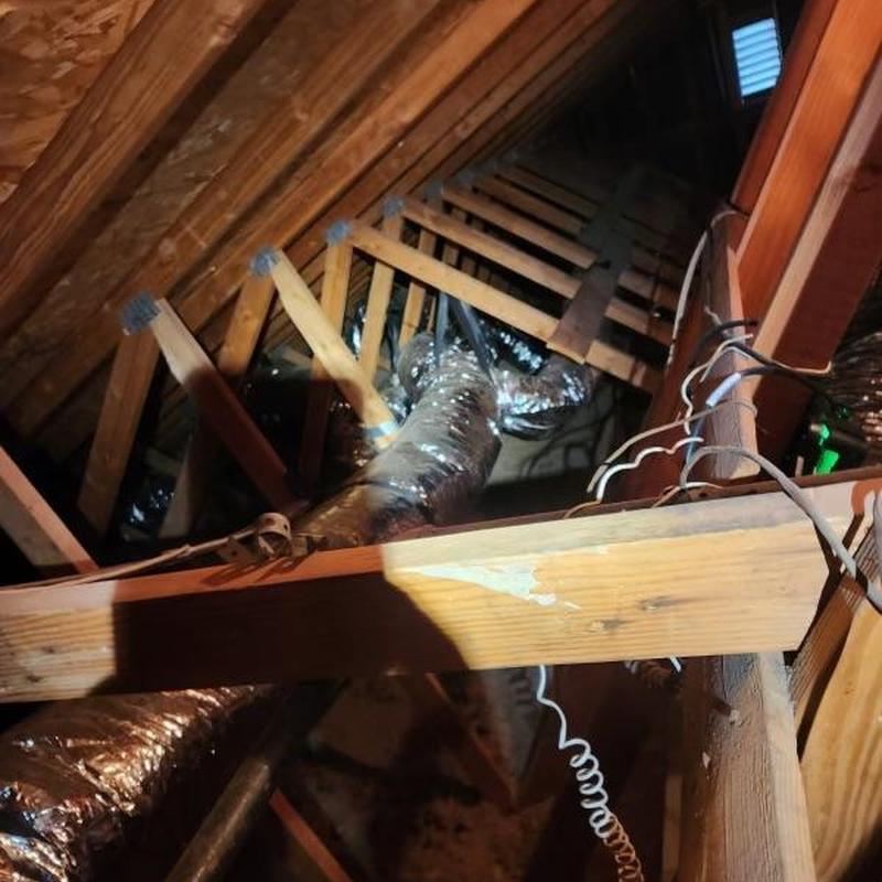 Ductwork installation in attic with wooden framing