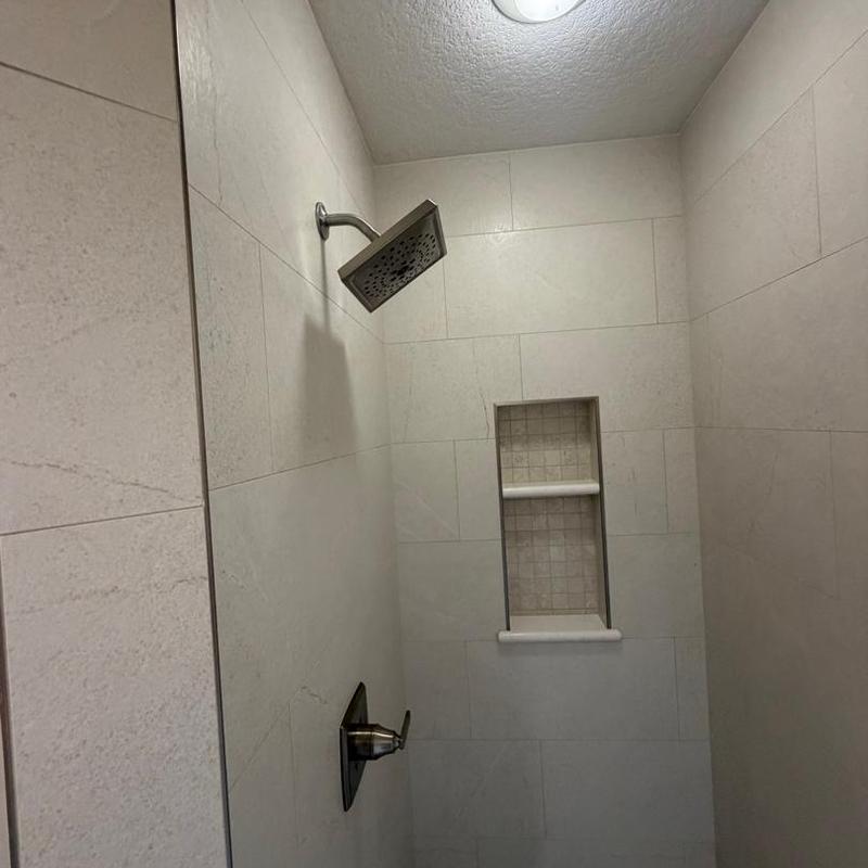 Showerhead and faucet fixtures in tiled shower wall