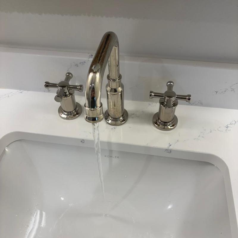 Lavatory faucet handle with running water in sink