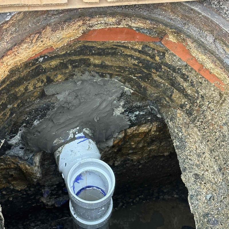 Grease trap with new PVC pipe and sealant installation