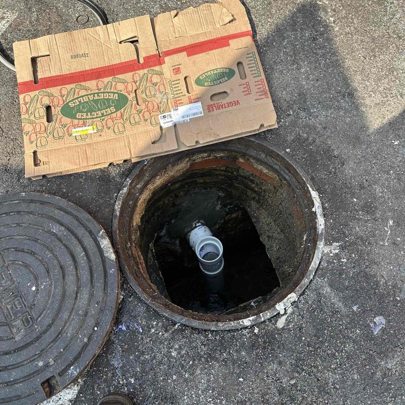 Grease trap inlet pipe installation in pavement hole