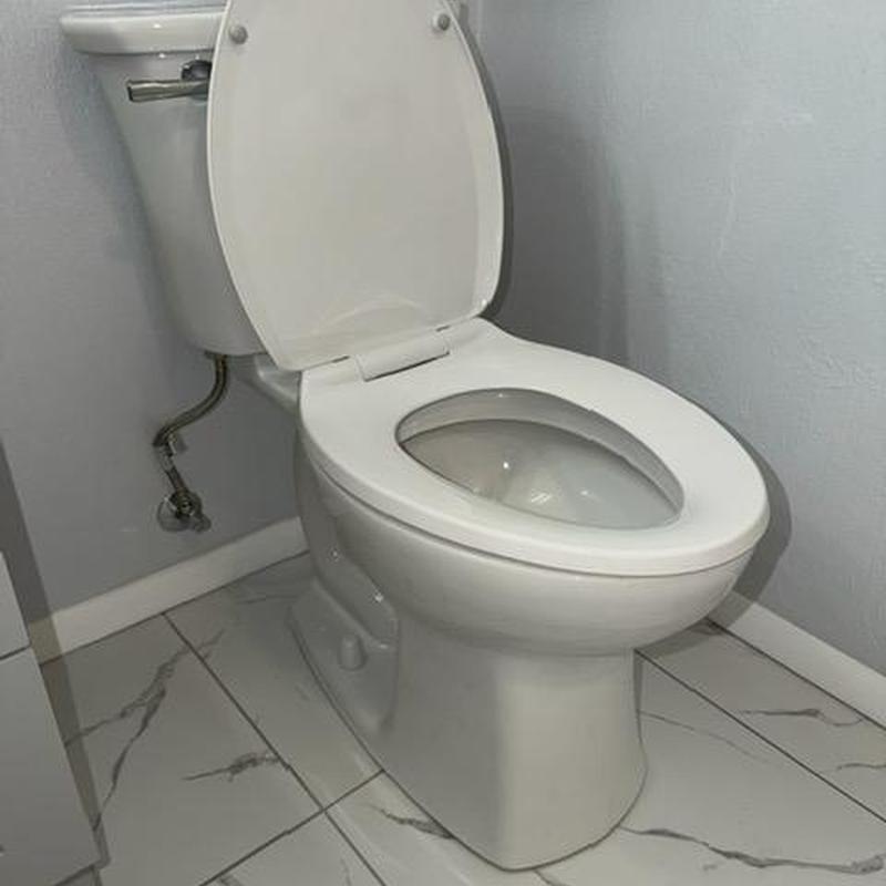 Toilet installation in bathroom with marble tile floor