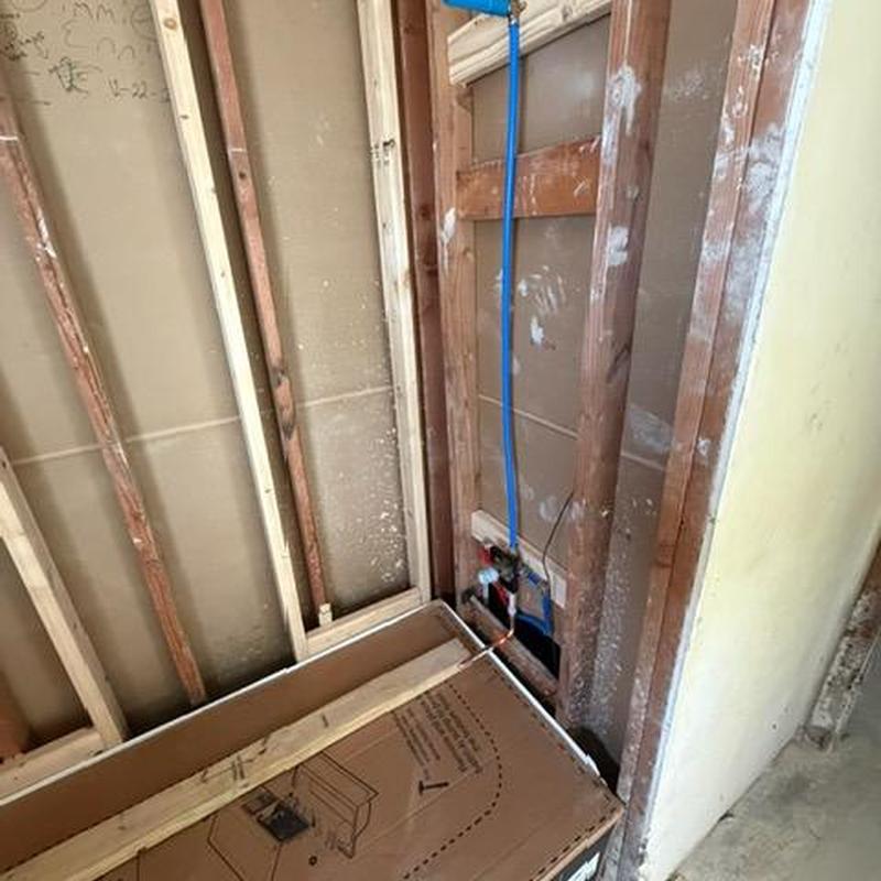 Bathtub rough-in plumbing with exposed studs and piping