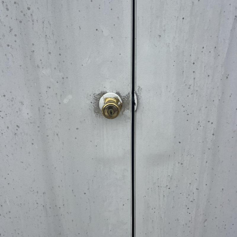 Deadbolt lock on exterior house door with weathering