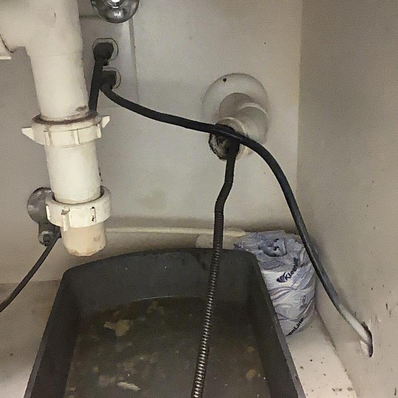 Kitchen sink drain pipe with plumber’s snake tool