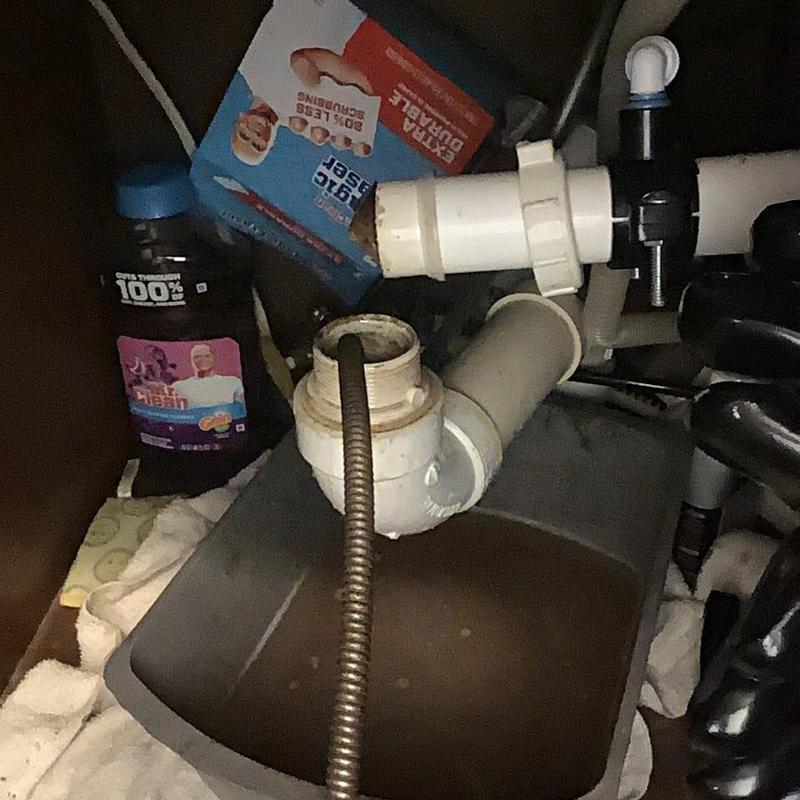 Kitchen sink drainpipe with snake auger tool under cabinet