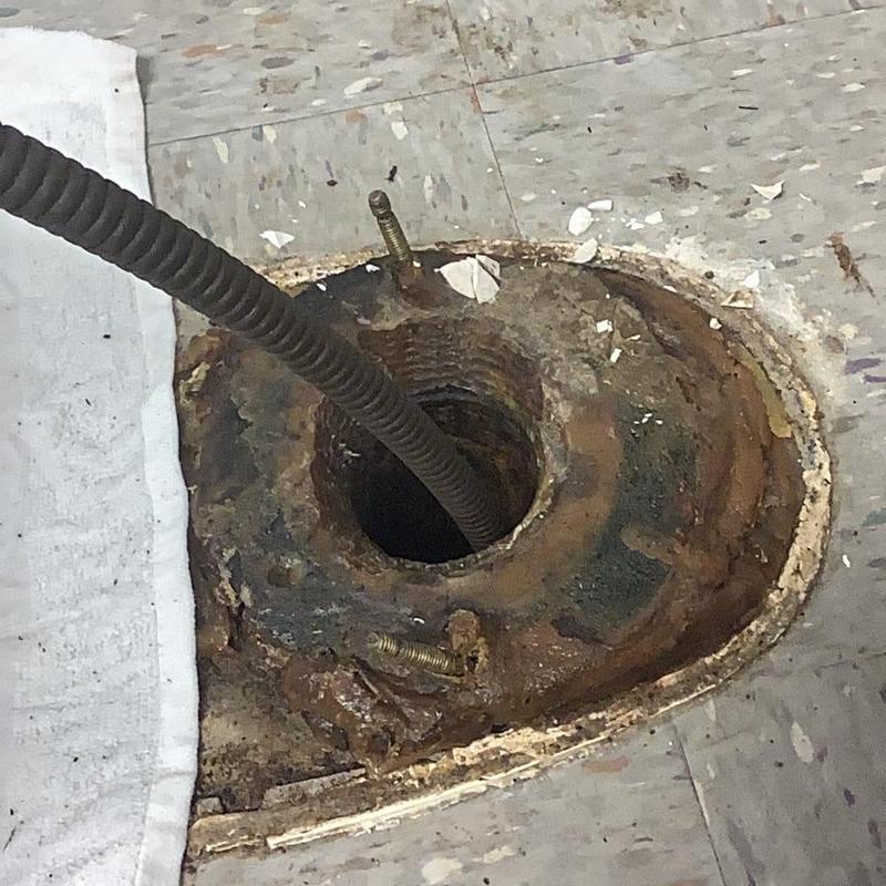 Main floor drain line with plumbing auger cleaning