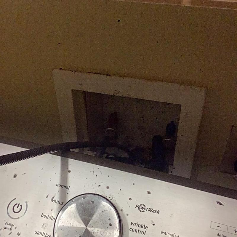 Washer drain connection with water hoses behind panel