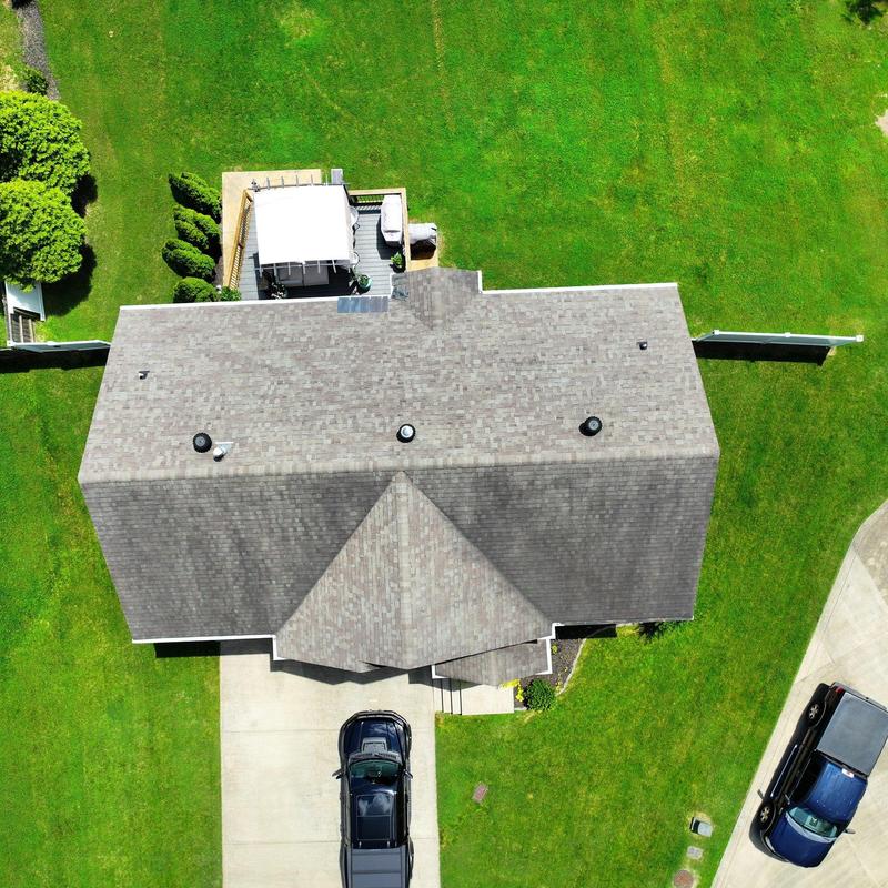 Roof shingles with vent and chimney components aerial view