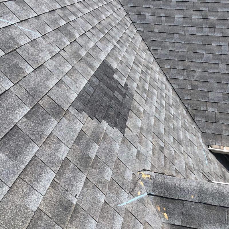 Roof shingles with hail damage and repair markings