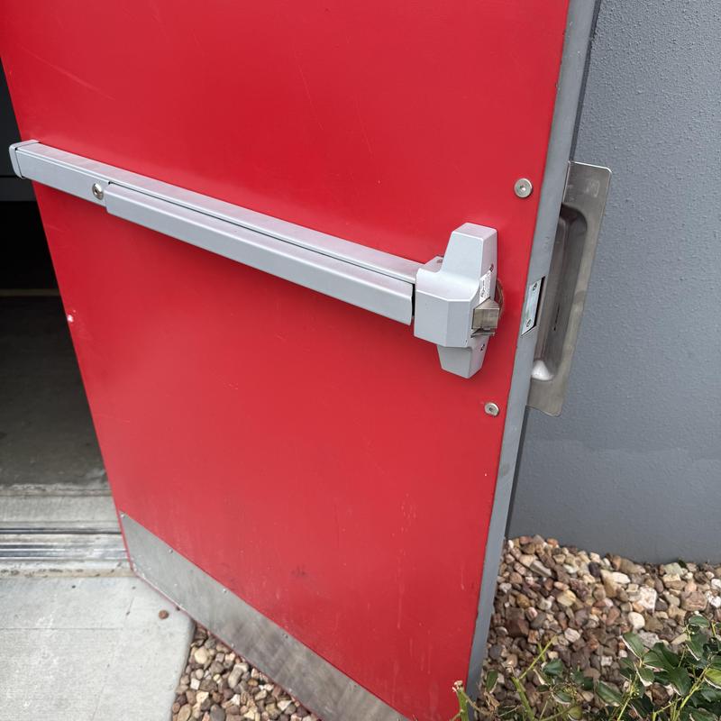 Exit bar and outside lever trim on red door