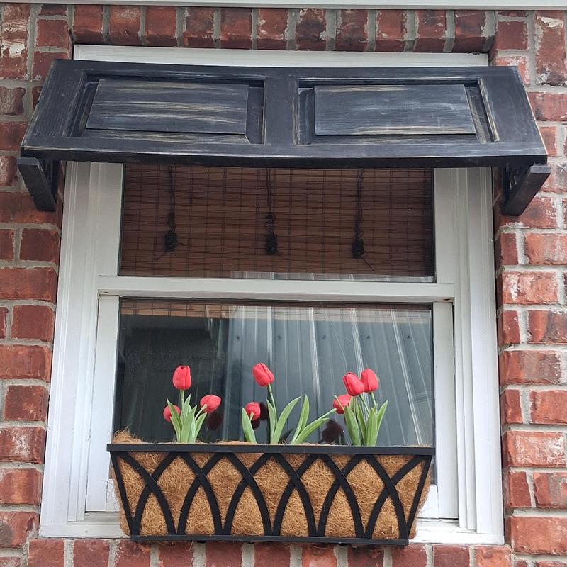 Custom wooden shutter above window with flower box