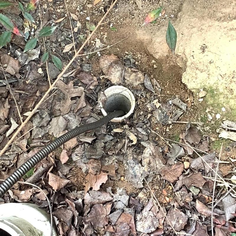 Septic tank main line with flexible drain snake outdoors