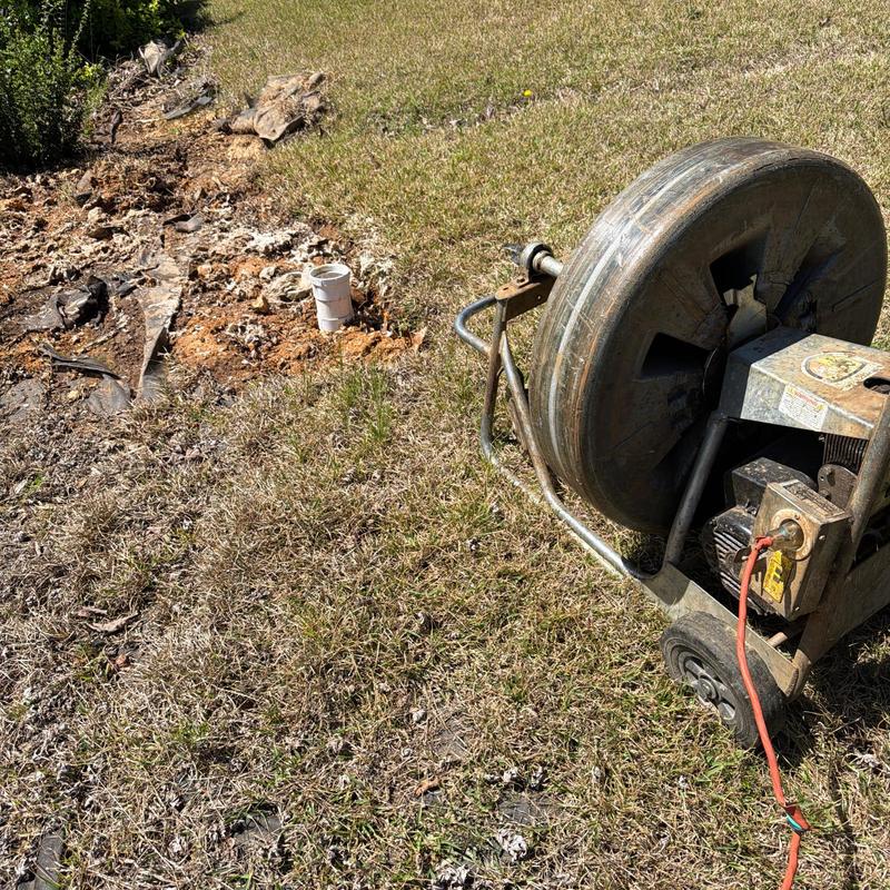 Main sewer line cable machine by cleanout outdoors